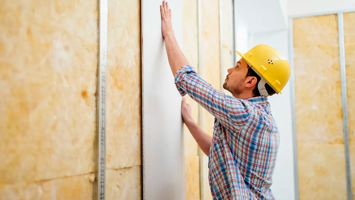 Worker installing drywall panels — drywall repair and installation service